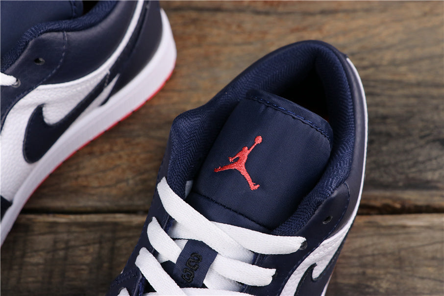 Top view of the sneaker showing white laces, dark blue padding, and a red Jumpman logo on the tongue.