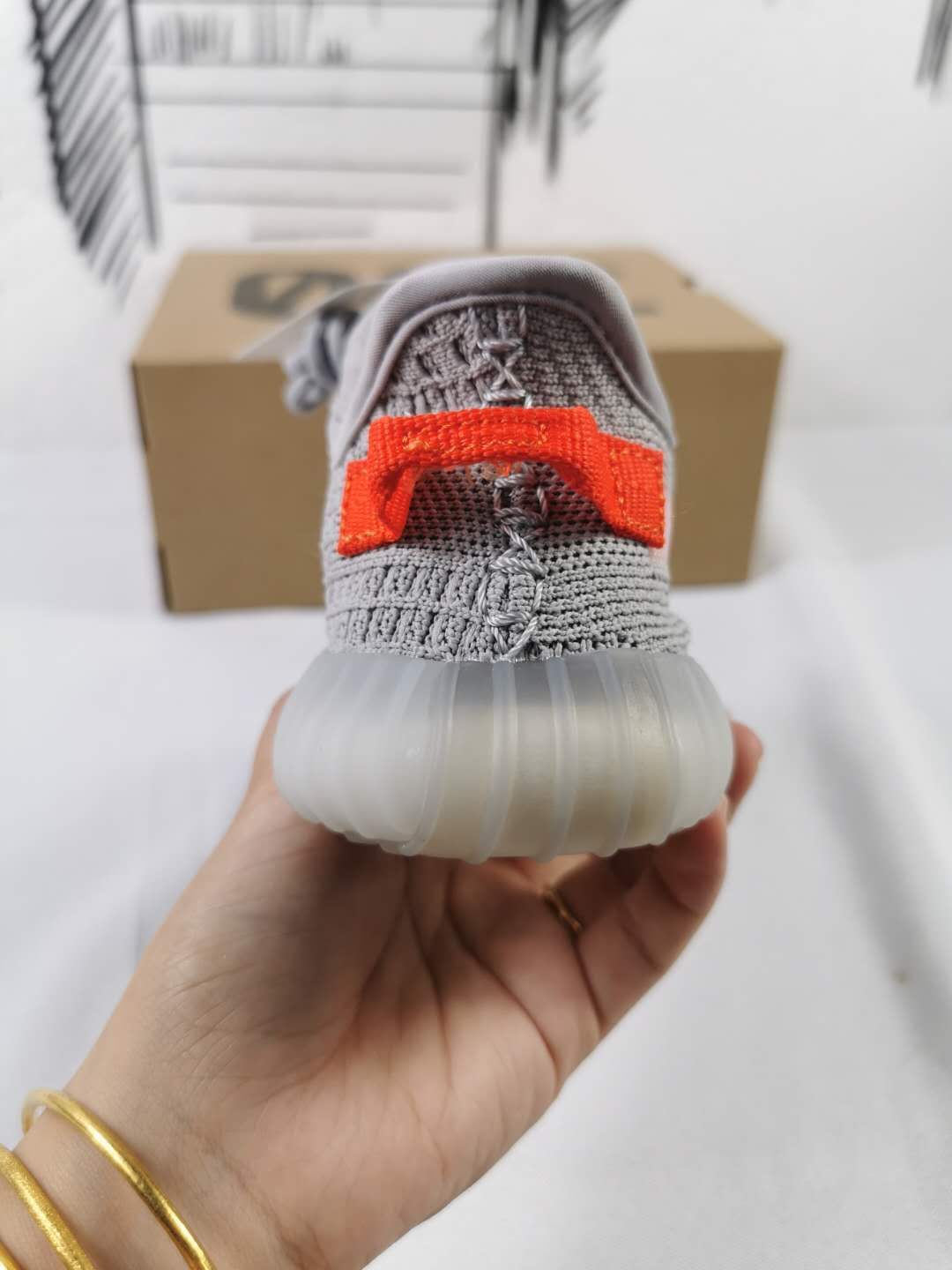 Rear view showing the orange heel pull tab and translucent outsole.