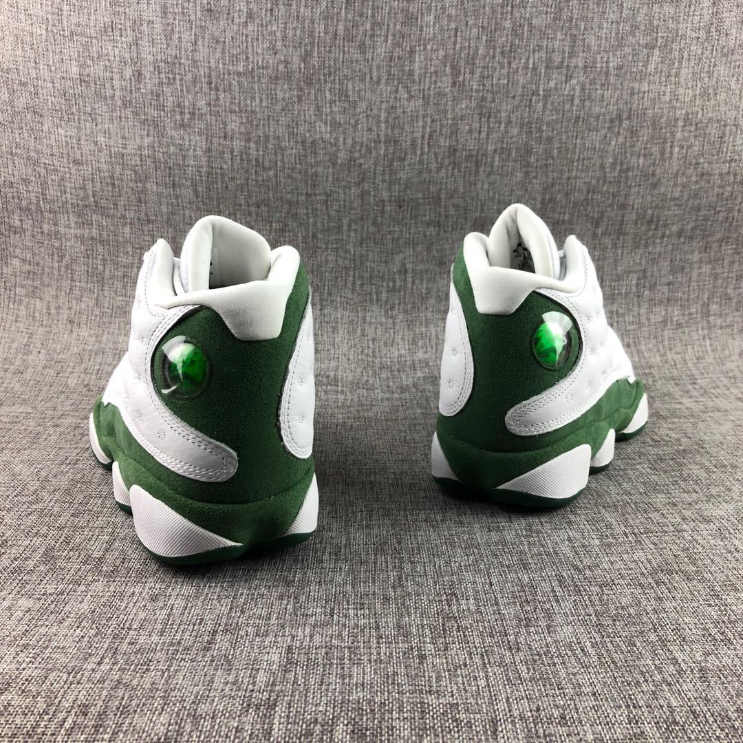 Rear view of white and green Jordan high-top sneakers showing green heel panels and translucent circular details.