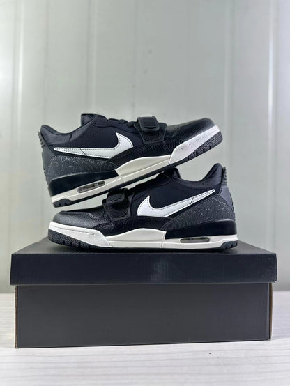 Pair of black and white low-top sneakers showing the side panels, forefoot straps, textured heel sections, and midsole windows.