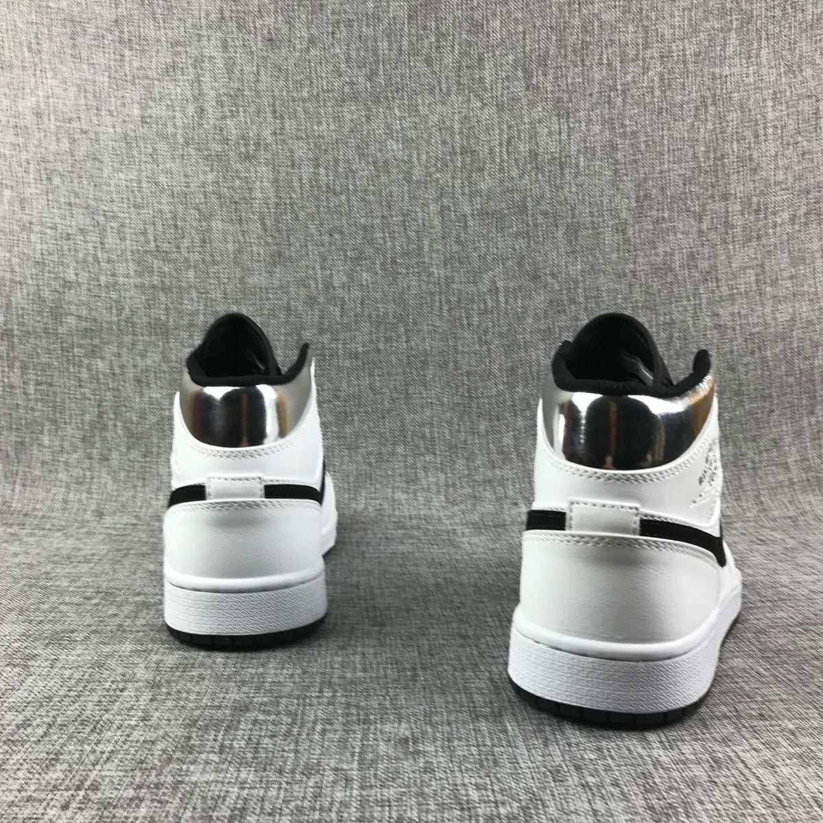 Rear view of the pair showing white heel panels, black trim, and metallic silver collars.