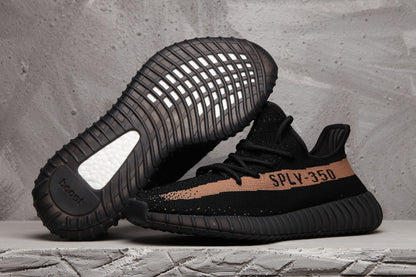 Black Yeezy 350 V2-style sneaker shown from the side and sole, with a peach-toned stripe and visible SPLY-350 lettering.