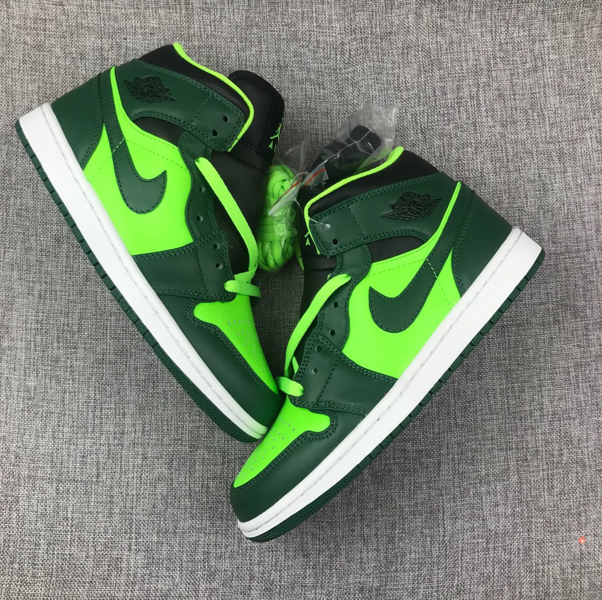 Top-down view of the pair showing fluorescent green laces, toe panels, and dark green overlays.