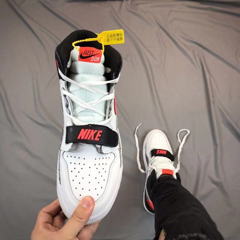 Top-down view of the sneaker showing the perforated toe, black strap, white laces, and contrasting tongue labels.