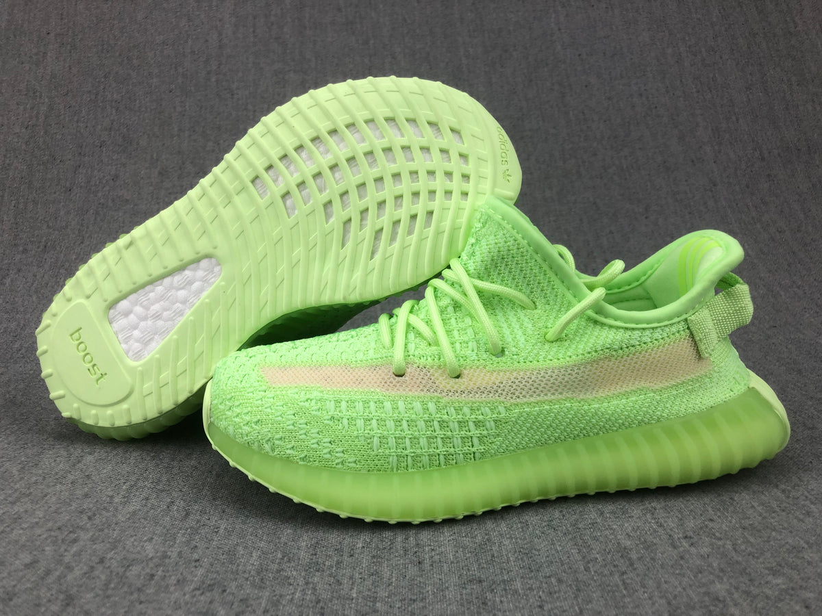 Sneakers shown with one outsole facing upward, revealing the patterned tread and visible Boost lettering.