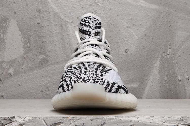 Front view of the sneaker showing the patterned knit toe box, white laces, and light-colored outsole.
