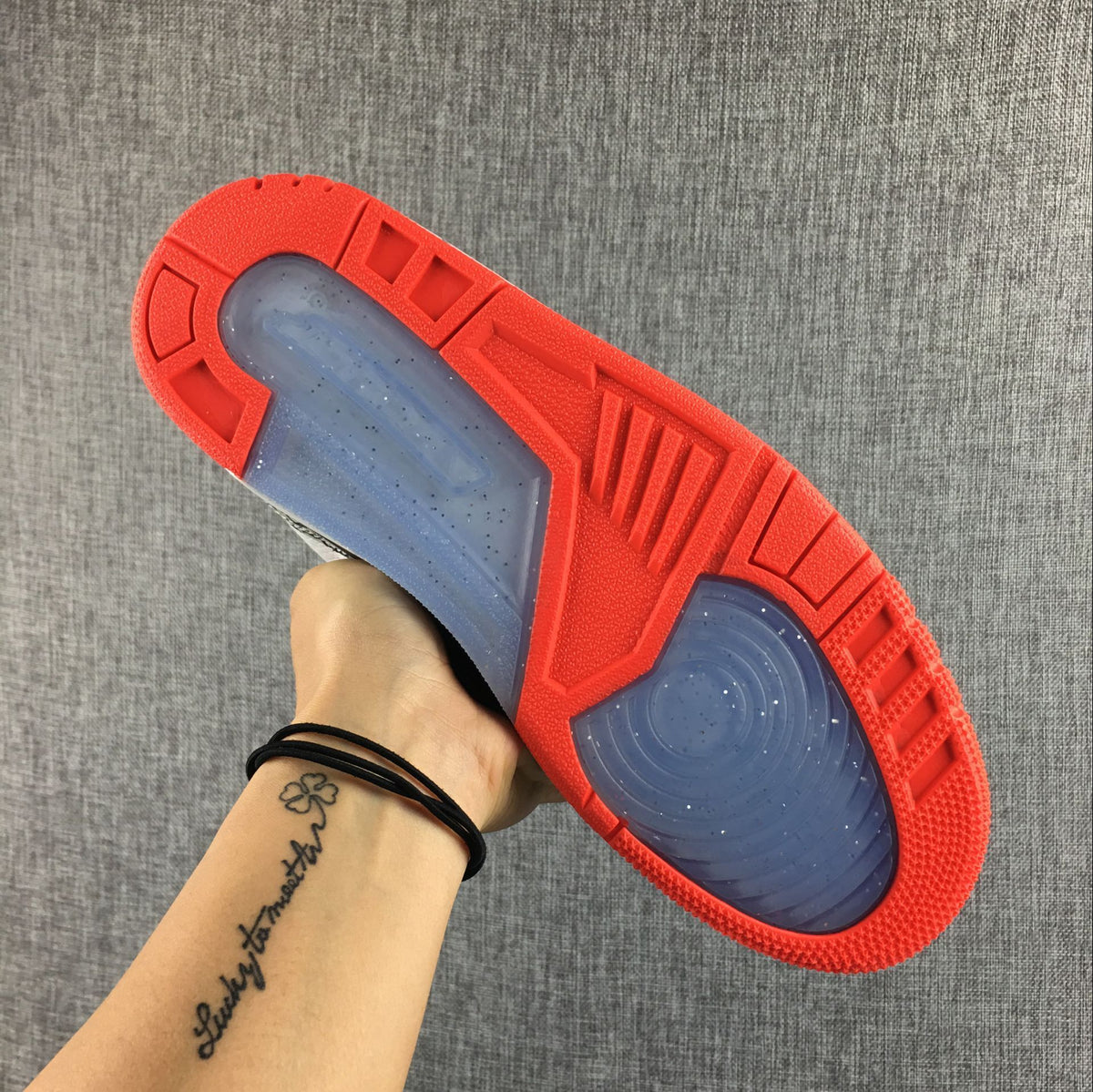 Outsole view with red tread and translucent sections.