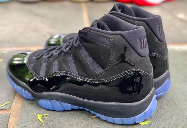 Pair of black high-top sneakers photographed outdoors from the rear and side.