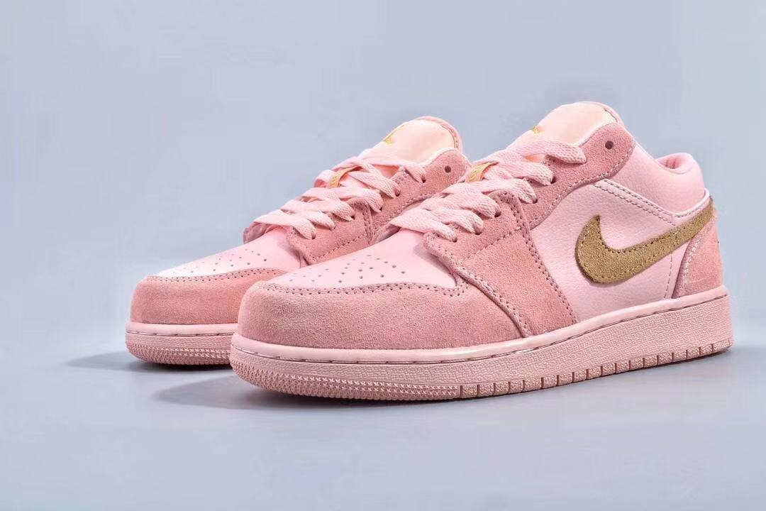 Angled product view showing both pink low-top sneakers and their gold side branding.