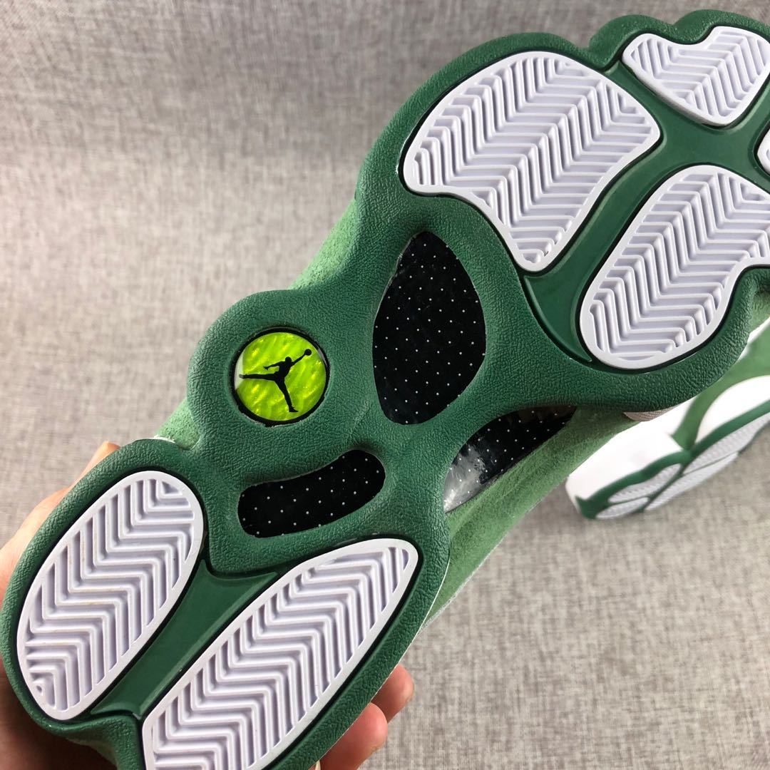 Close-up of the outsole showing white herringbone traction sections, green rubber, and translucent details.