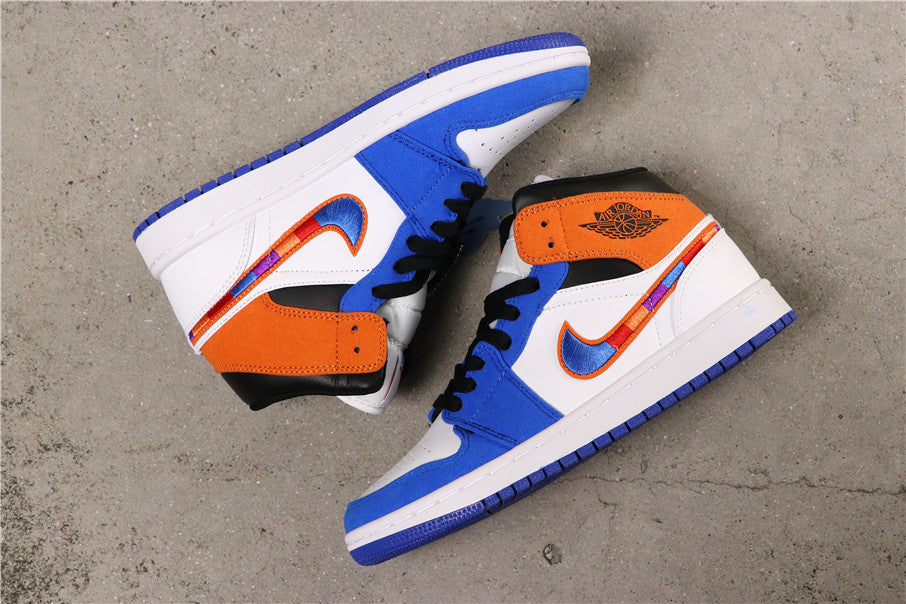 Angled view of the pair showing the blue, white and orange color blocking and mid-top construction.