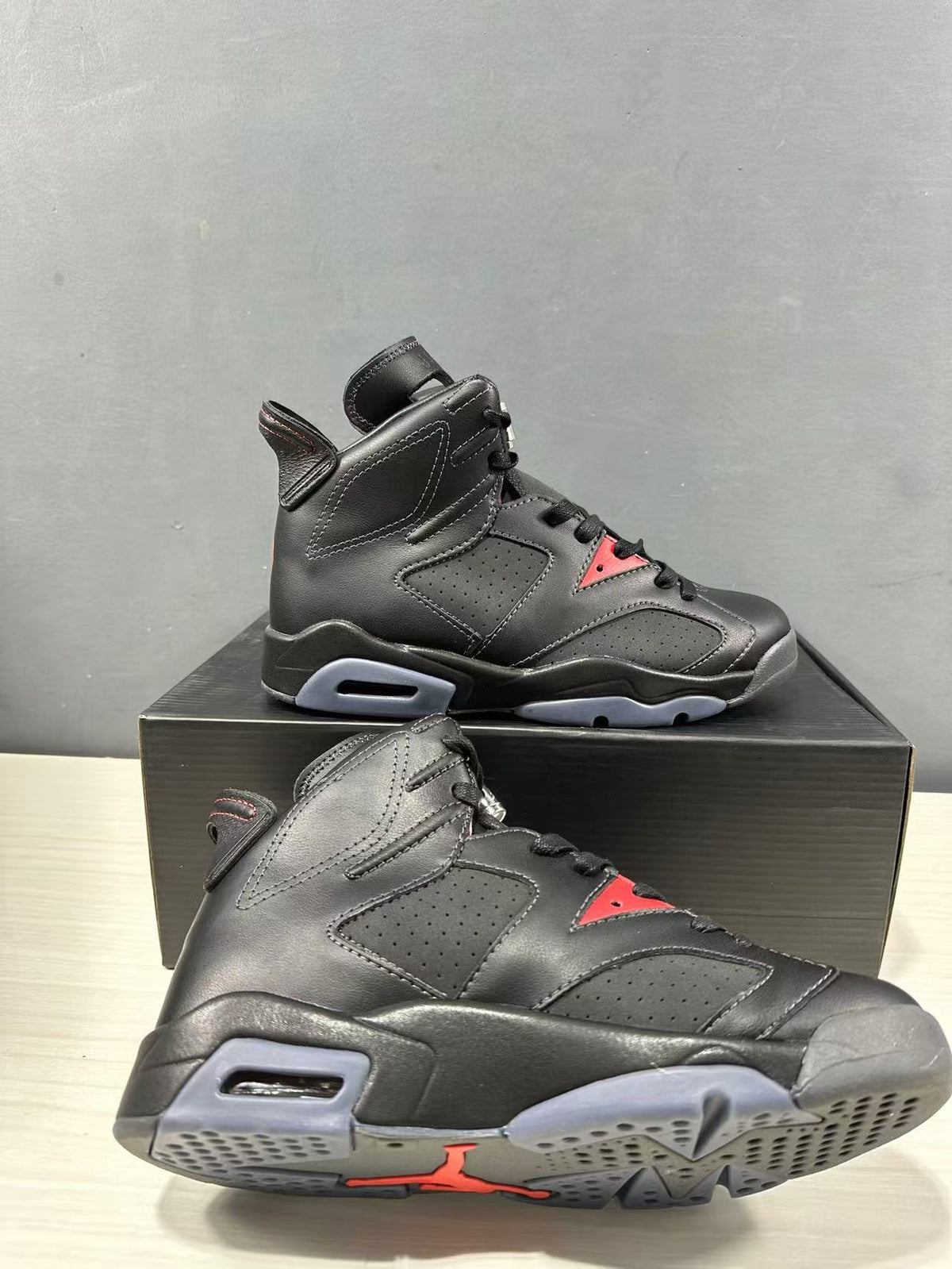 Close angled view showing the black upper, gray outsole sections, and red outsole branding.