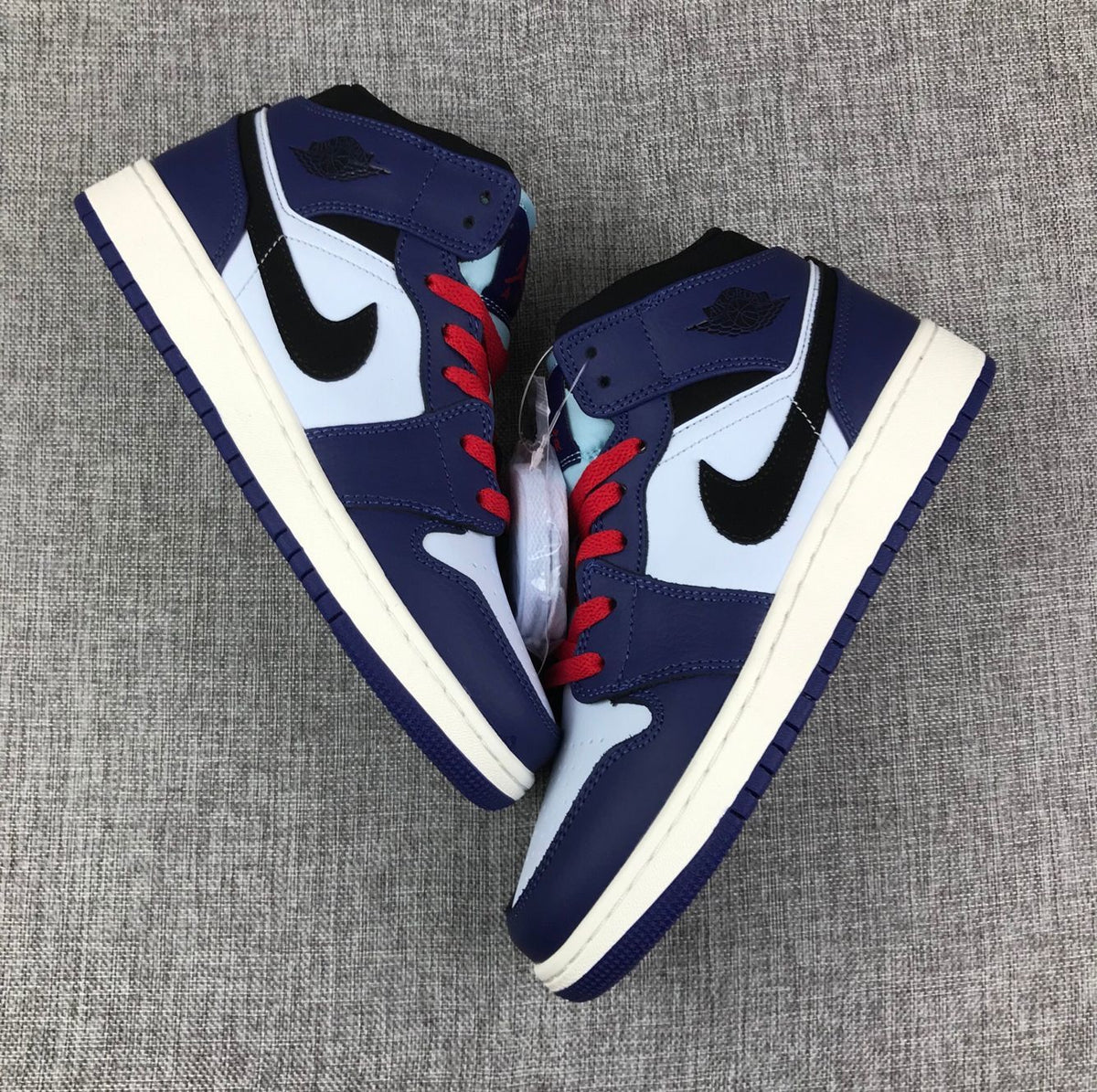 Top-down view of the pair showing the mid-top collars, red laces and light blue tongue details.