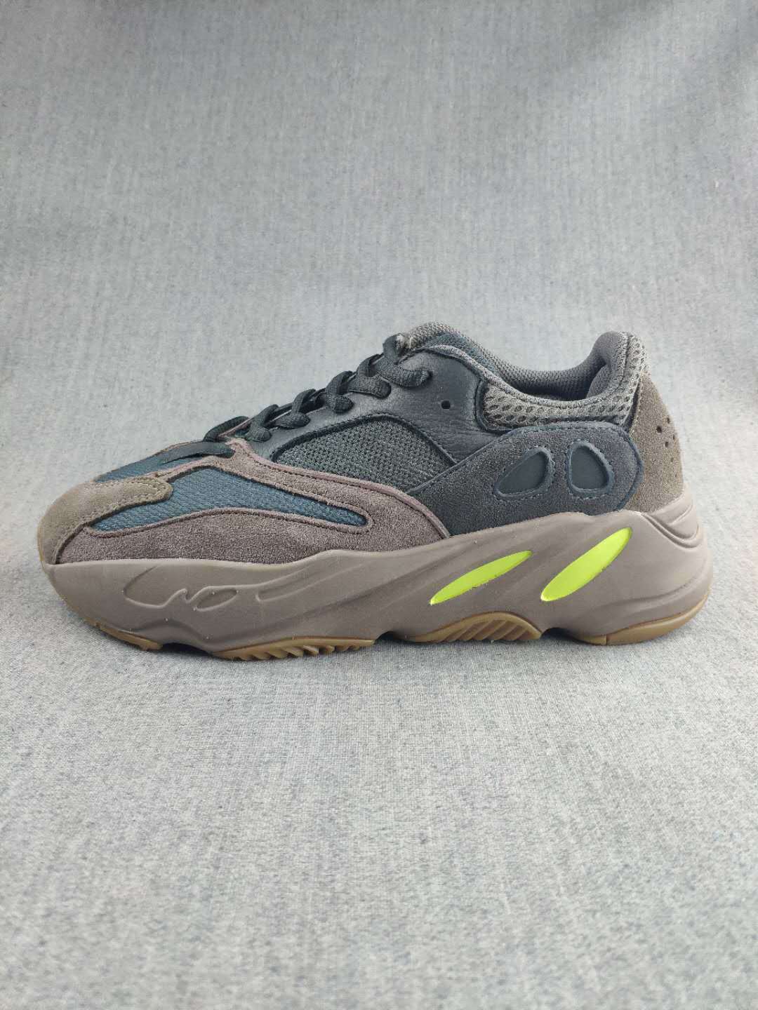 Side profile highlighting the gray upper, blue panels, lime midsole accents, and textured outsole.