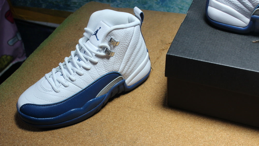 Angled view of one sneaker showing its laces, tongue, and navy side overlay.