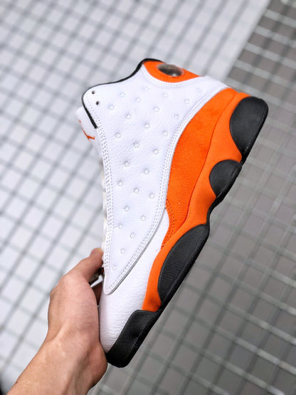 Side view of a white, orange, and black Air Jordan 13 sneaker