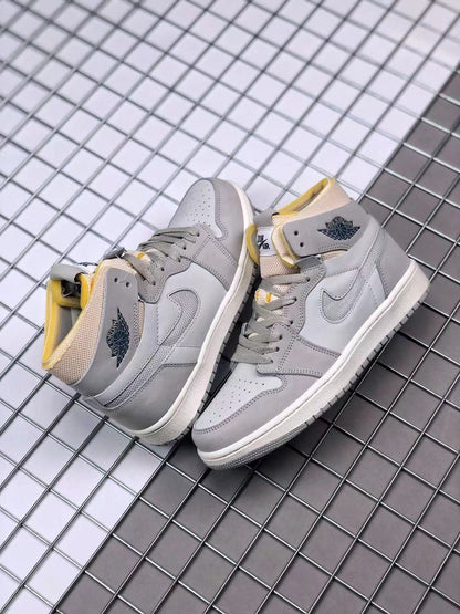 Pair of gray and white high-top sneakers showing yellow collar accents and winged basketball branding.