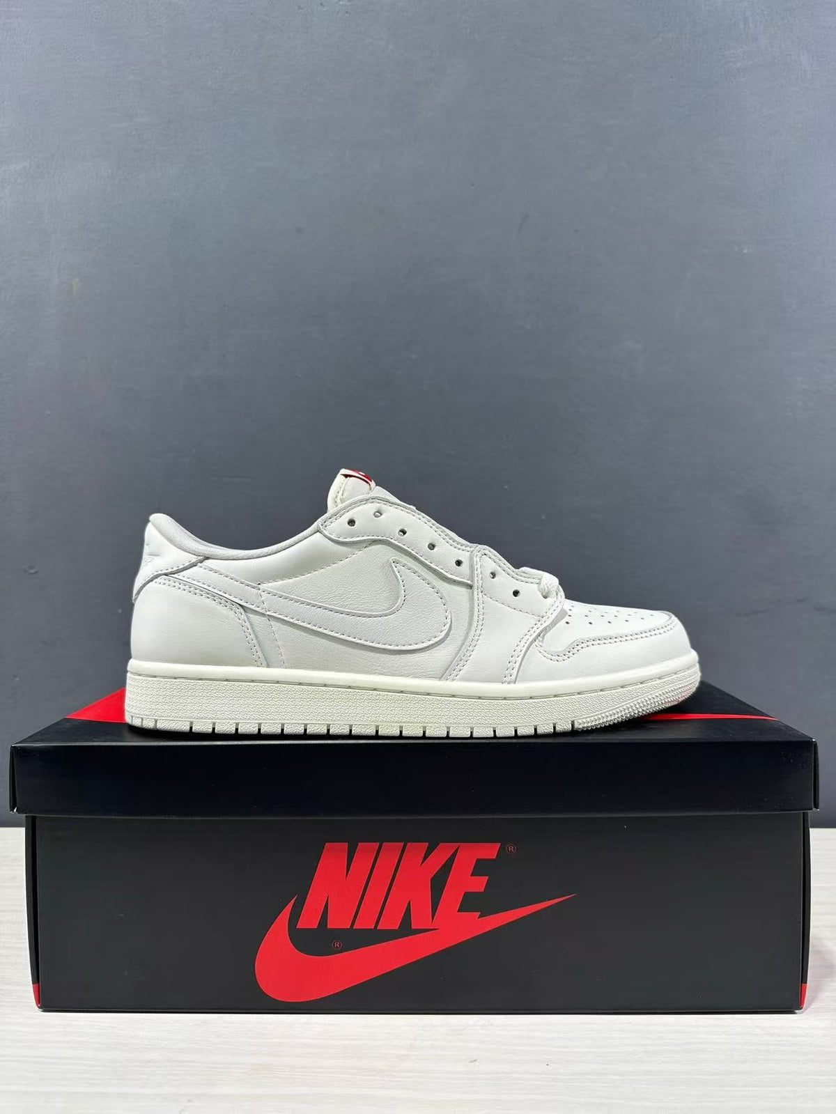 Side profile of a white low-top Jordan sneaker displayed on a branded shoe box.