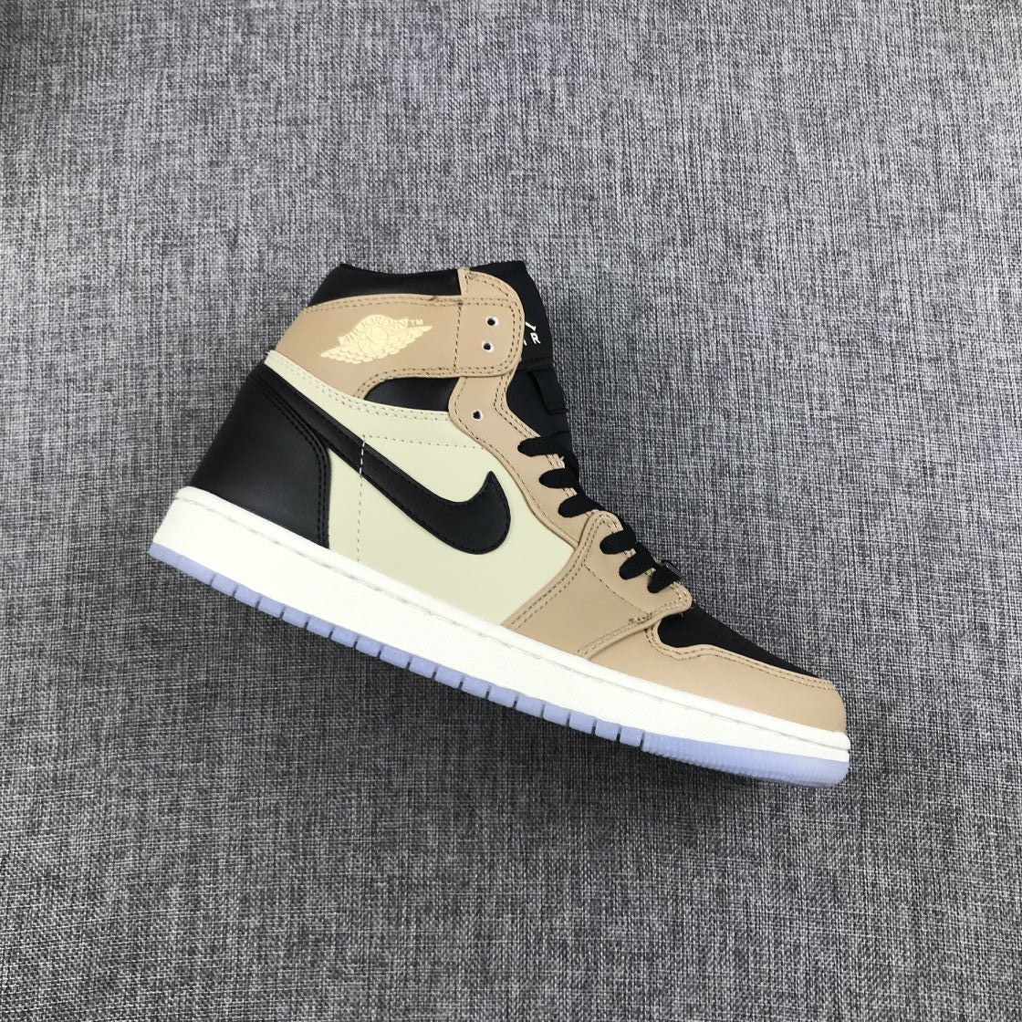 Side view of a beige, cream, and black Jordan high-top sneaker on gray fabric.
