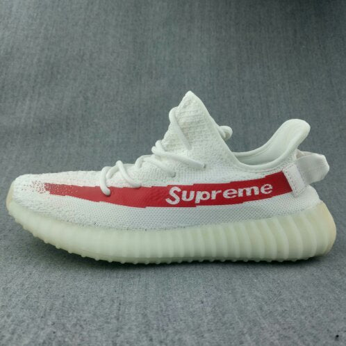 Side profile of the white sneaker with red “Supreme” stripe lettering and a translucent yellow-tinted sole.