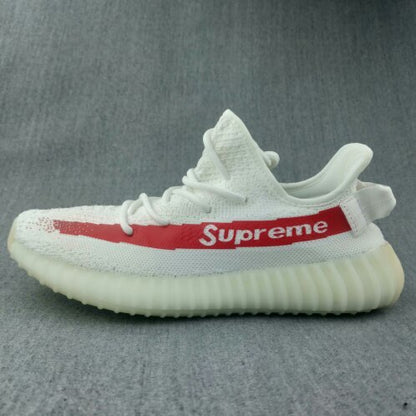 Side profile of the white sneaker with red “Supreme” stripe lettering and a translucent yellow-tinted sole.