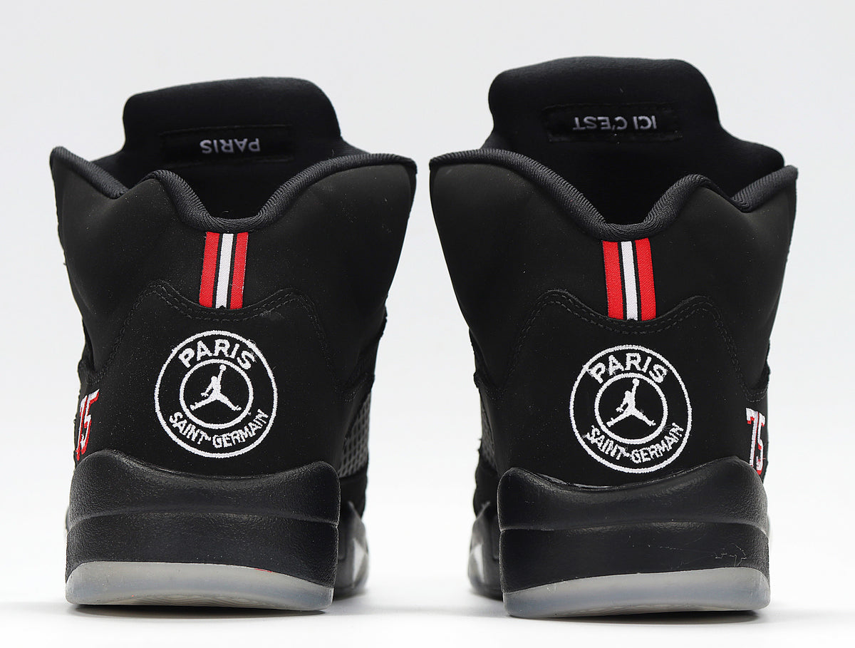 Rear view of the sneakers showing Paris Saint-Germain heel emblems and red-white stripes