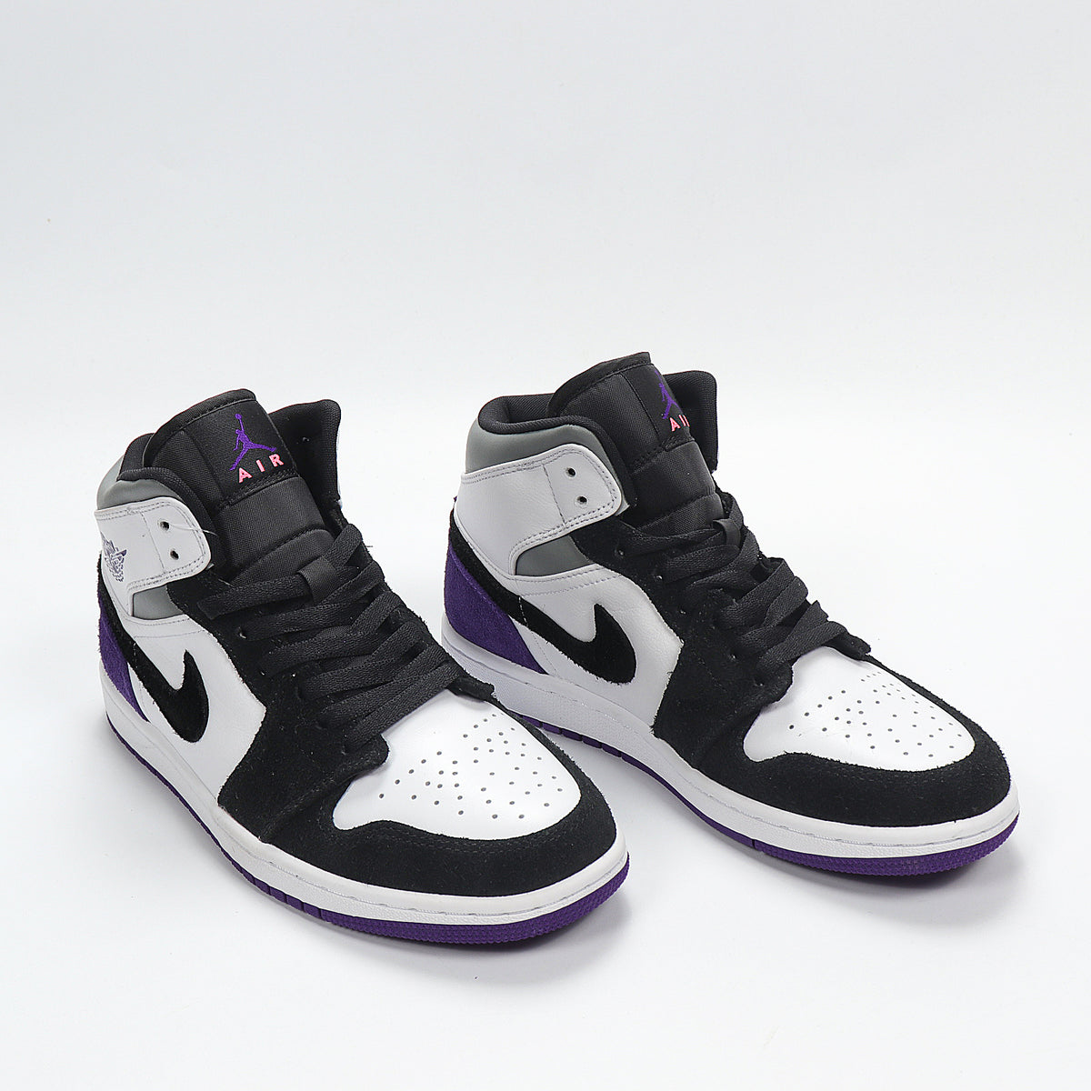 Three-quarter front view showing the black, white, and purple color blocking, padded collars, and high-top construction.