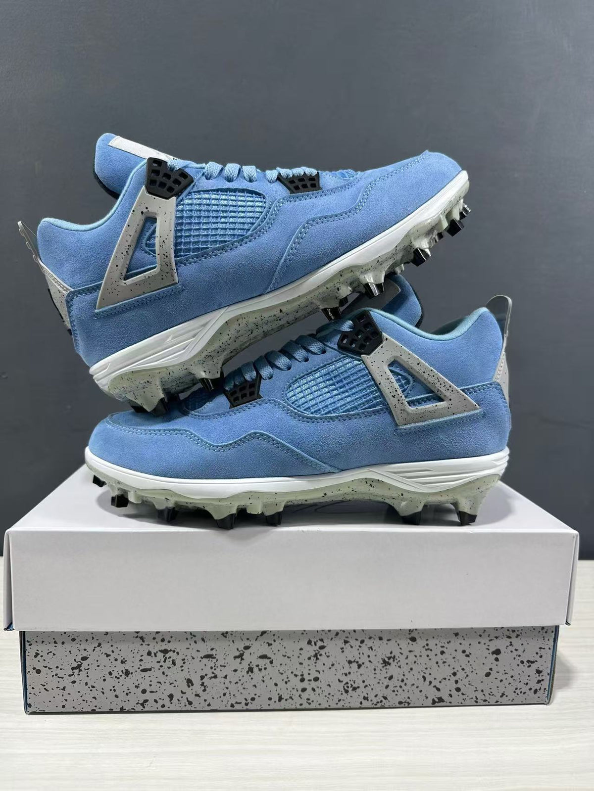 Two University Blue sneakers stacked to show their side panels, molded wings, and studded outsoles.