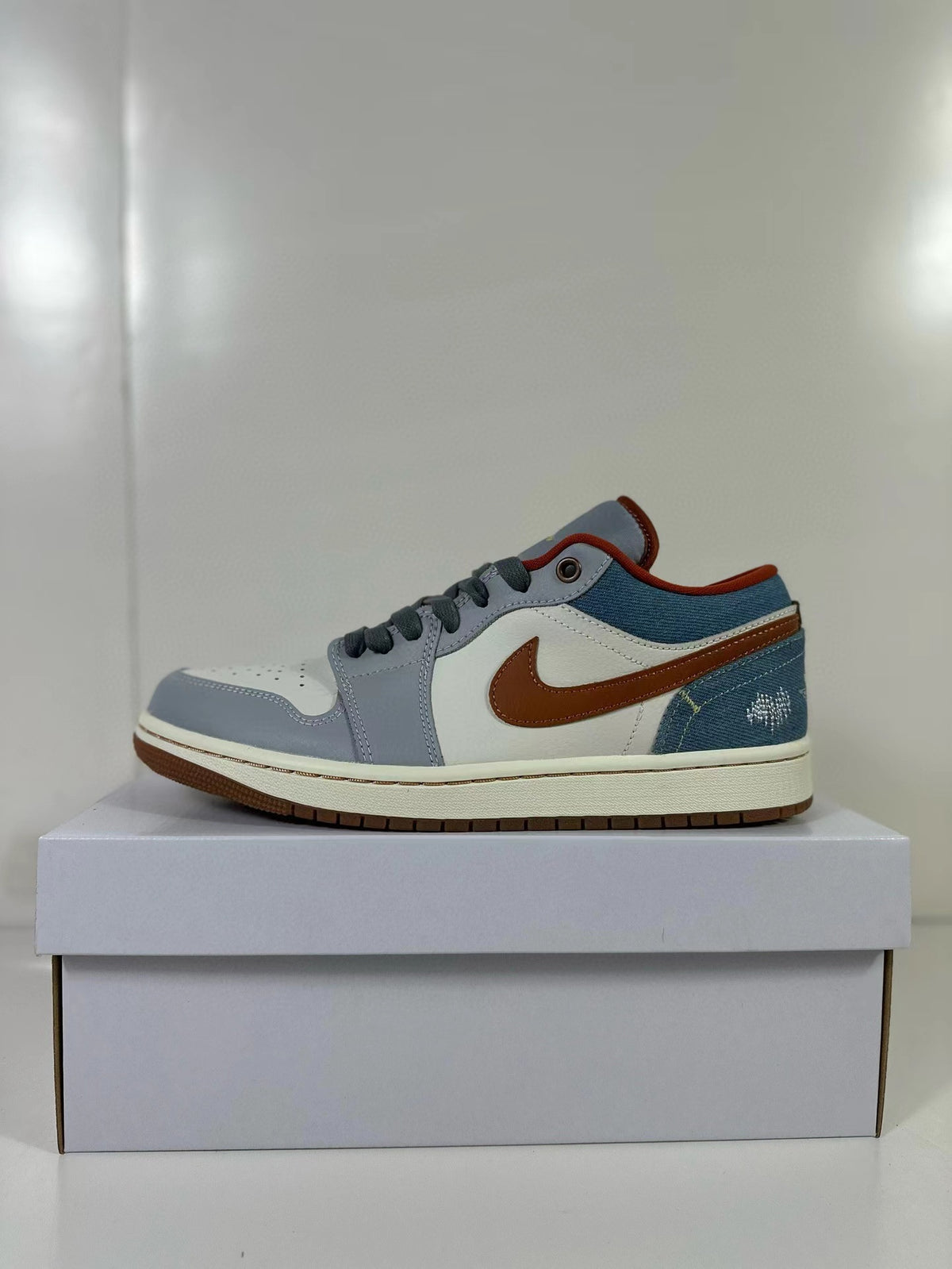 Side view of a blue, gray, off-white, and brown Air Jordan 1 Low sneaker