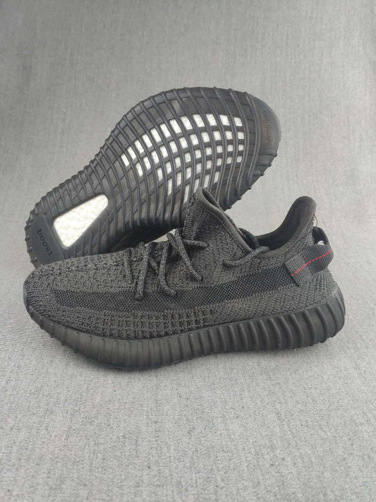 Pair of black knit low-top sneakers shown from the side and outsole.