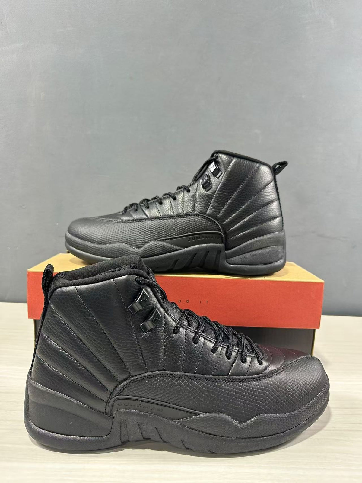 Close view of the black Jordan high-top pair highlighting the panel stitching and textured forefoot.