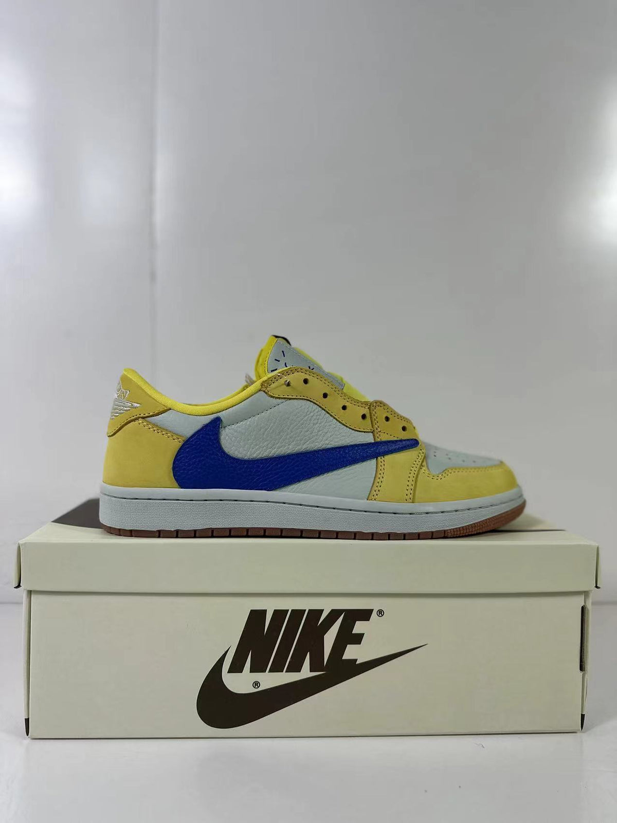 Side profile of a single yellow, light blue and blue low-top sneaker.