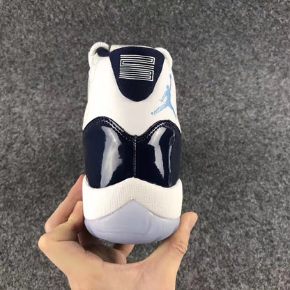 Rear view showing the navy heel overlay, white heel panel, blue logo, and translucent outsole.
