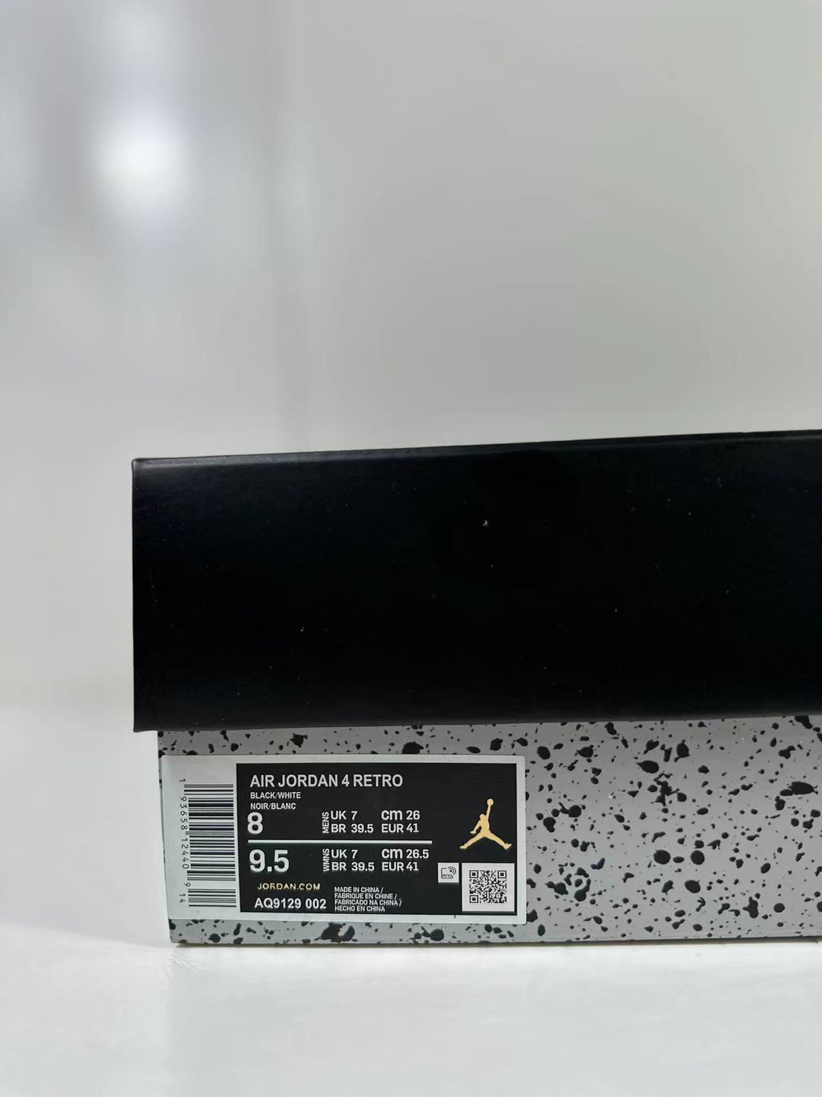 Shoe box label showing AIR JORDAN 4 RETRO, black and white color text, and style code AQ9129-002.