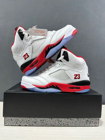 Pair of white and red high-top sneakers arranged on a box, showing mesh side panels, black midsole sections, and translucent outsole areas.