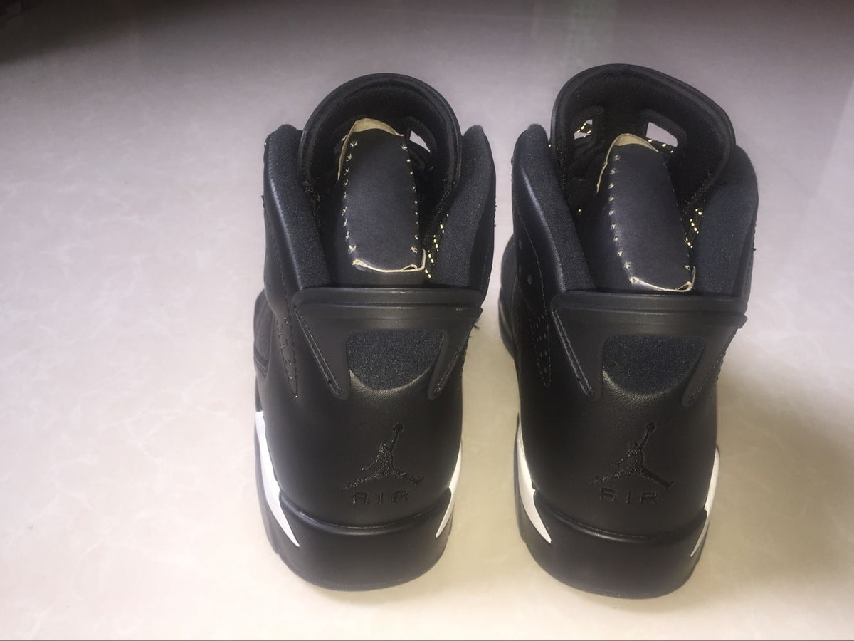 Rear view of the black high-top sneakers showing padded collars, heel tabs, and Jordan Air branding.