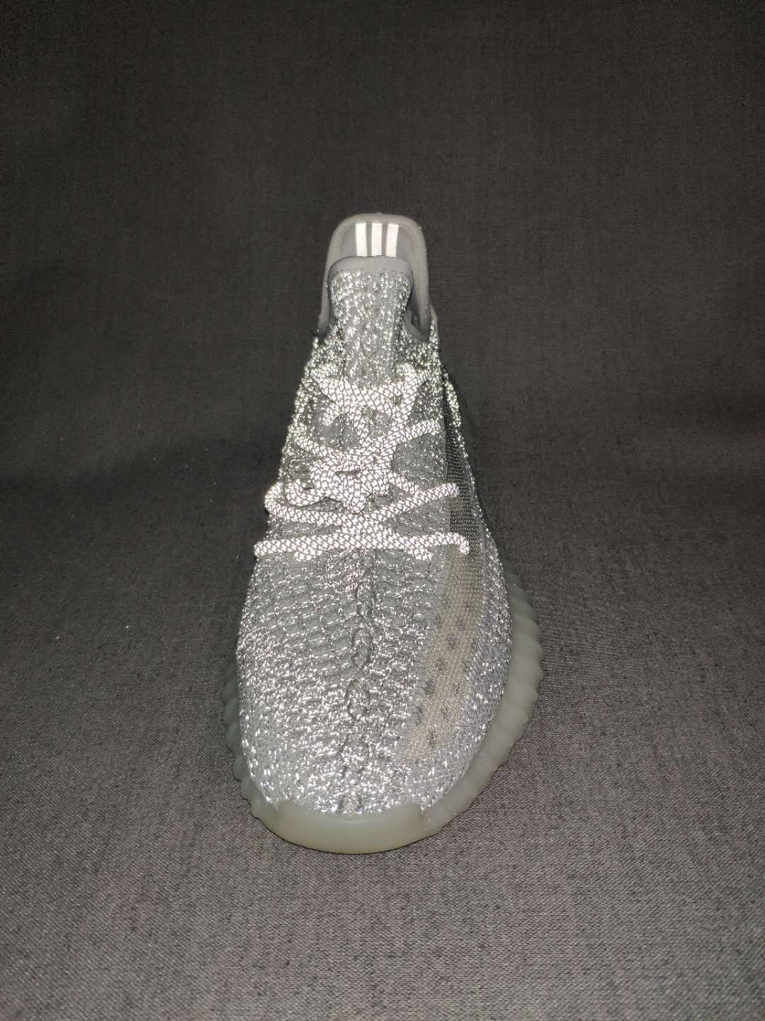 Top-front view highlighting the textured knit upper, lace arrangement, tongue, and translucent outsole.