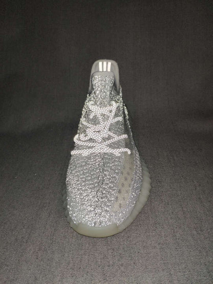 Top-front view highlighting the textured knit upper, lace arrangement, tongue, and translucent outsole.