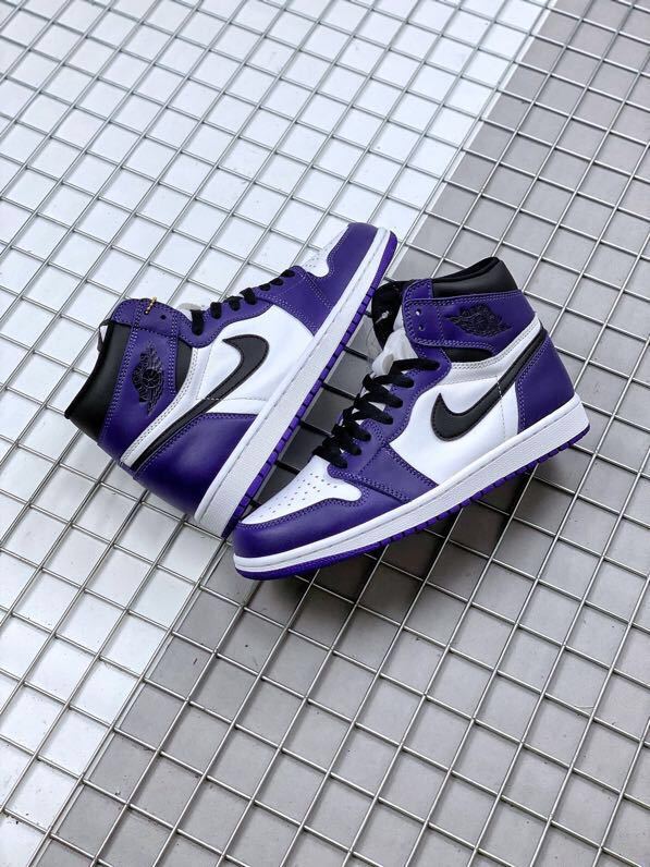 Pair of purple, white, and black high-top sneakers displayed on a metal grid surface.