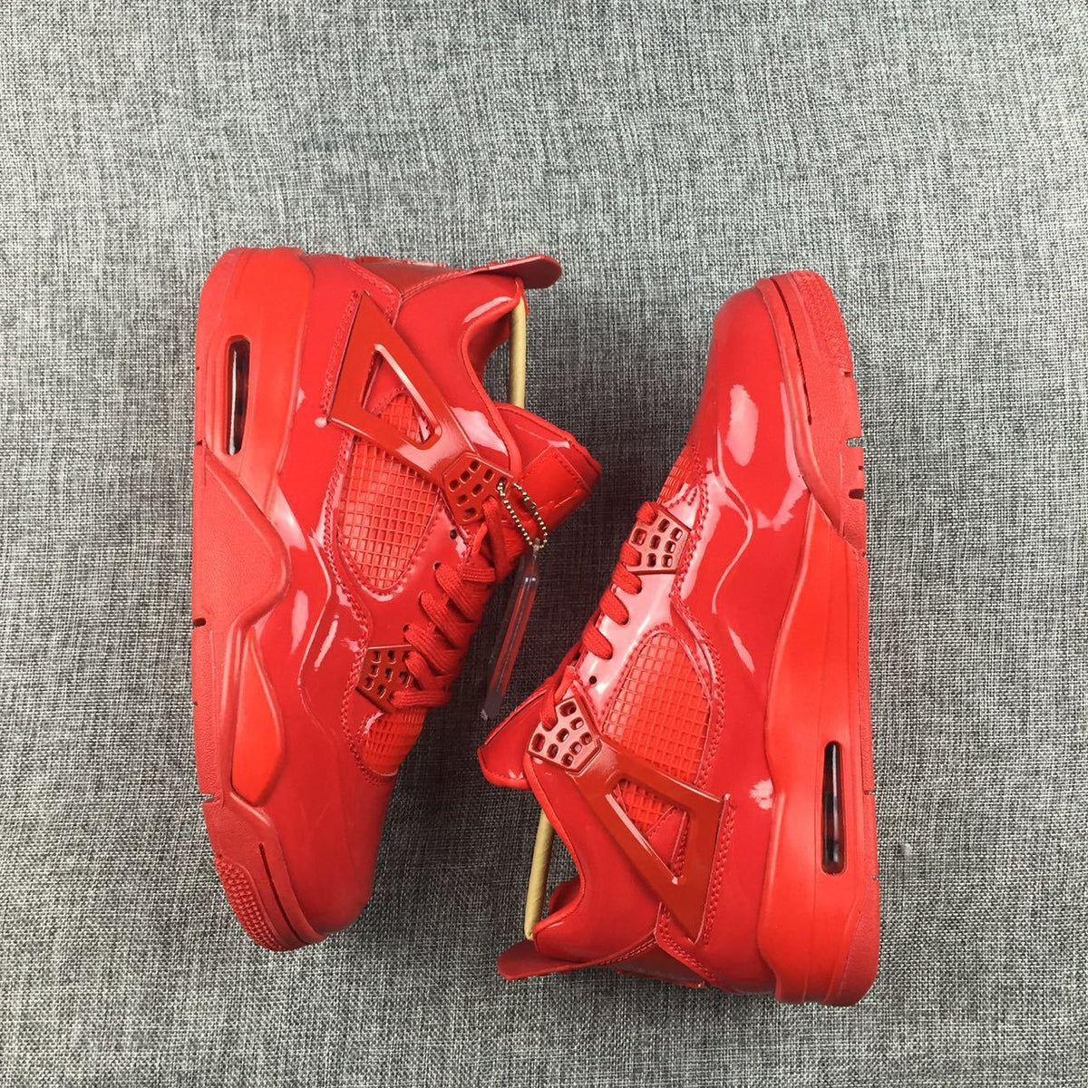 Pair of red high-top sneakers shown from opposite sides with matching glossy uppers and outsoles.