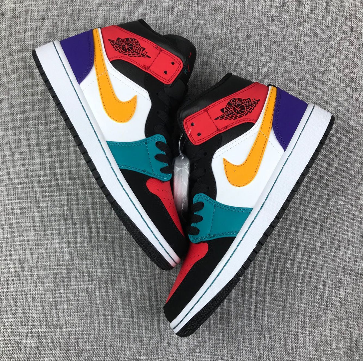 Pair of multicolor Jordan high-top sneakers shown from opposing side angles.