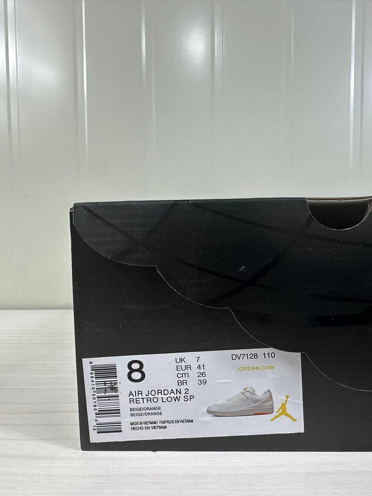 Black shoe box with a label showing size information, the Air Jordan 2 Retro Low SP name, color text, and style code DV7128-110.