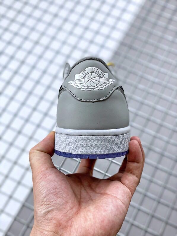 Rear view of the sneaker showing Dior Air branding on the grey heel tab and a blue outsole edge.