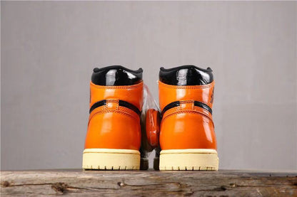Rear view of the pair showing orange heel panels, black collars, and cream-colored outsole edges.