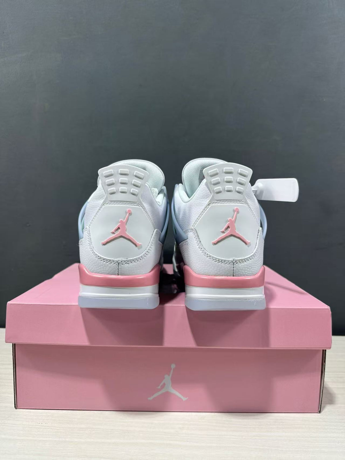 Rear view of the pair showing pink Jordan heel logos, white uppers, and pink midsole accents.