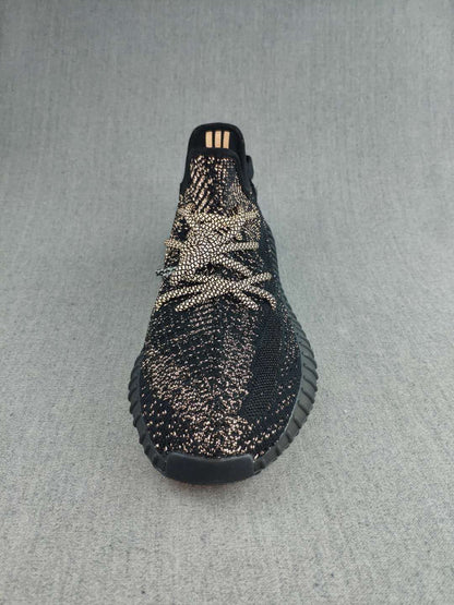 Top view of a black lace-up sneaker showing the patterned upper and rounded toe.
